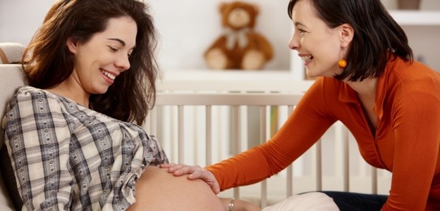 Sister touching pregnant belly