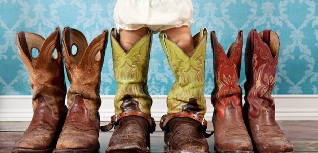 baby wearing her daddy cowboy boots