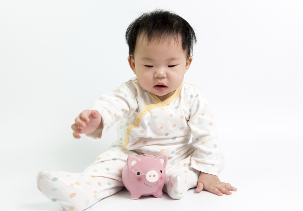 Asian baby with piggy bank - are we rich