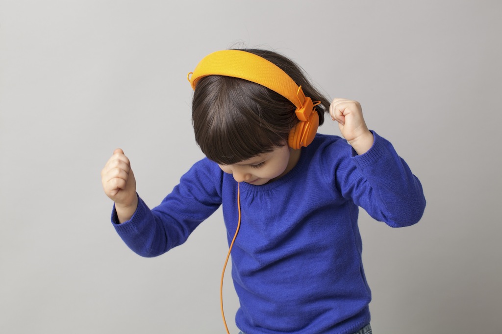 happy young child dancing in listening to music