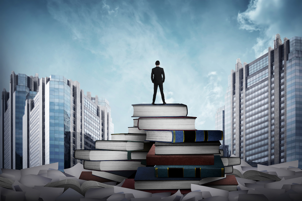 Business man standing on the top of books
