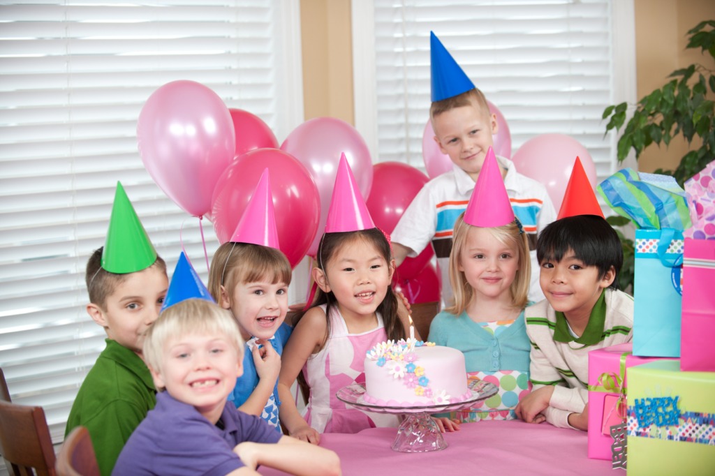 Children at a birthday party with a cake.
