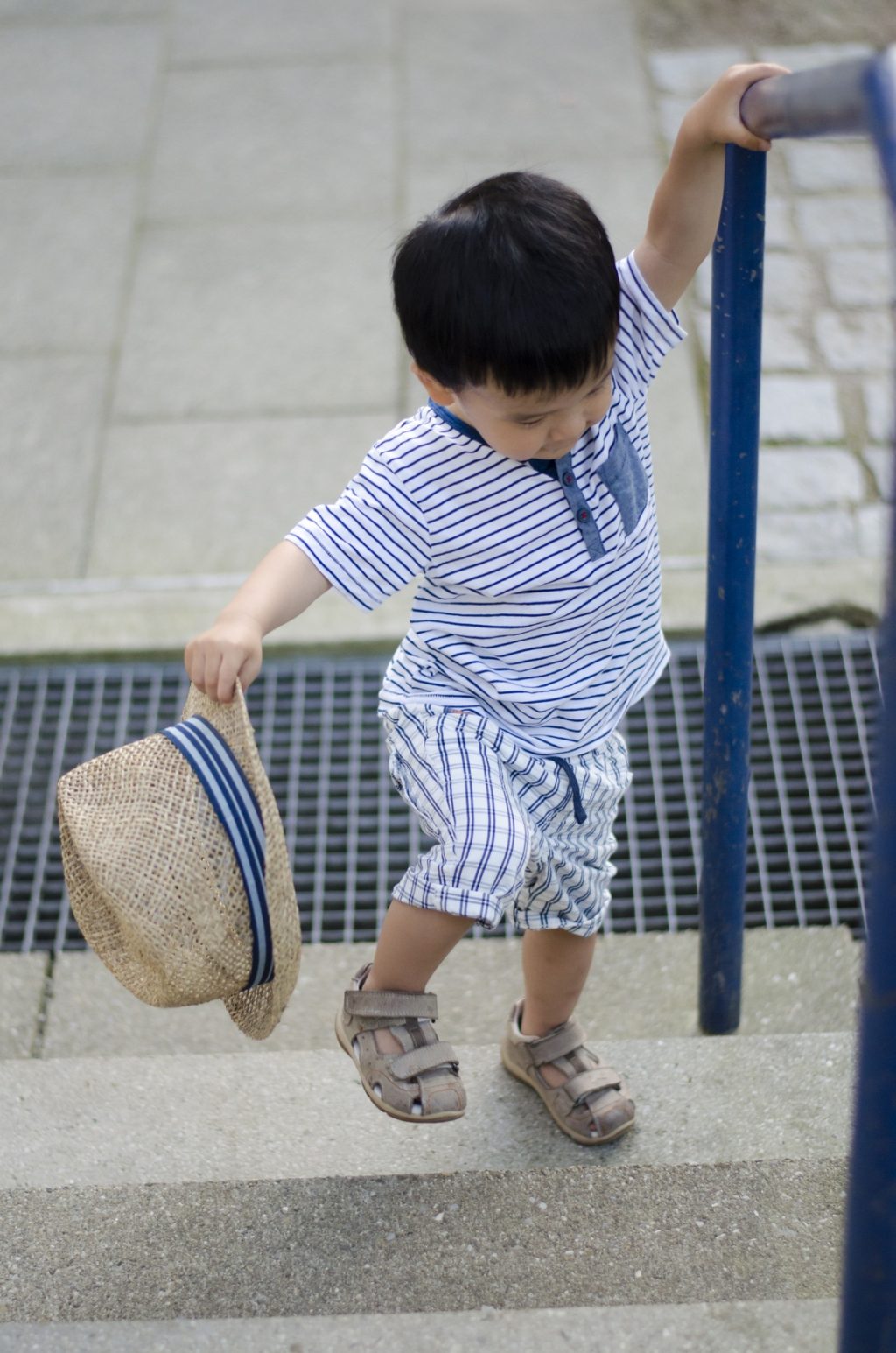 Little toddler asian boy playing outdoors