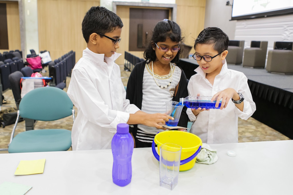 10 year olds Nehru Sachin, Senthilkumar Illakkiya, and Lim Yi Chen demonstrate their experiment for Science Buskers