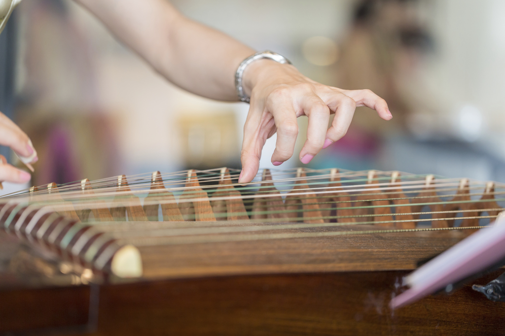 Hand of woman playing guzheng.