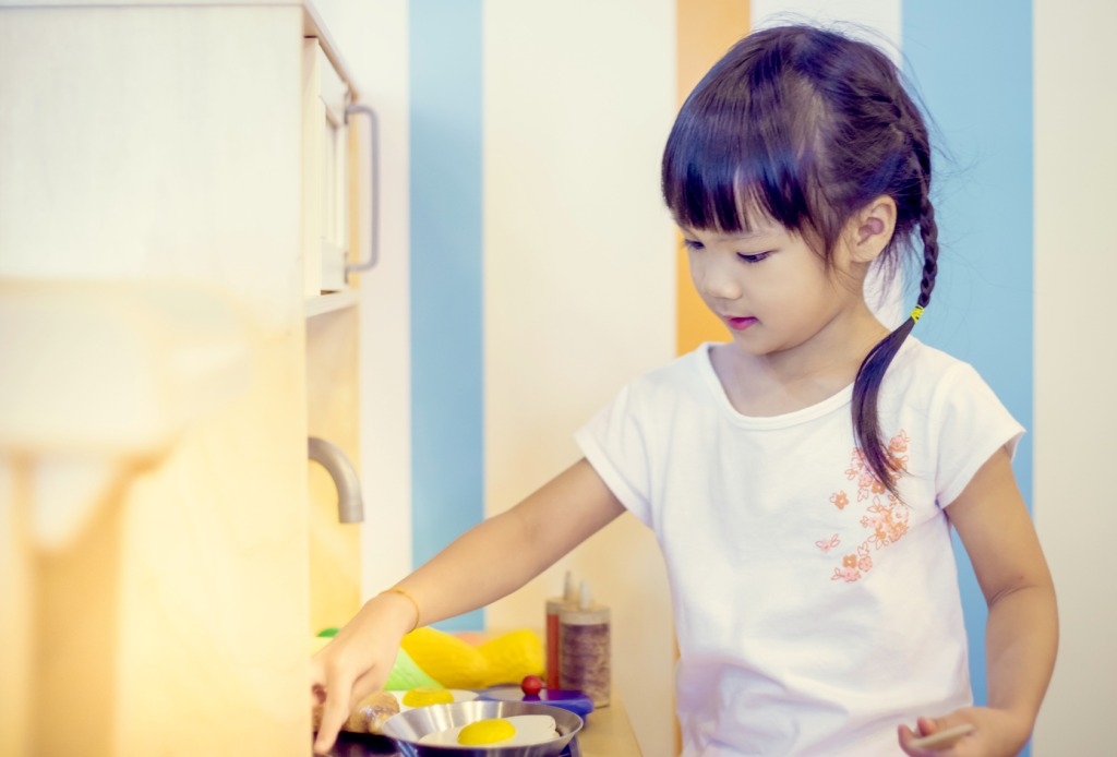Asian Girl playing with Cooking Toy