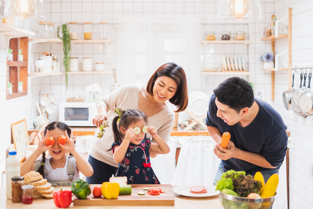 Asian family enjoy playing and cooking food in kitchen at home