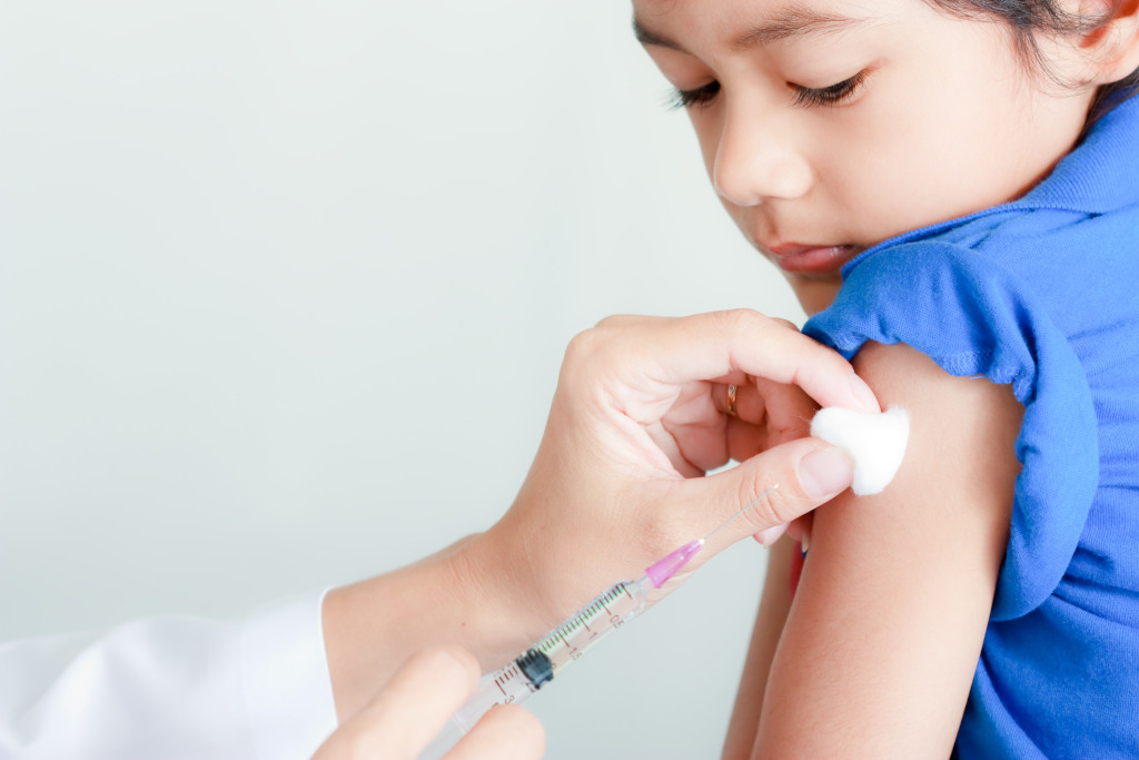 Doctor giving injection to boy