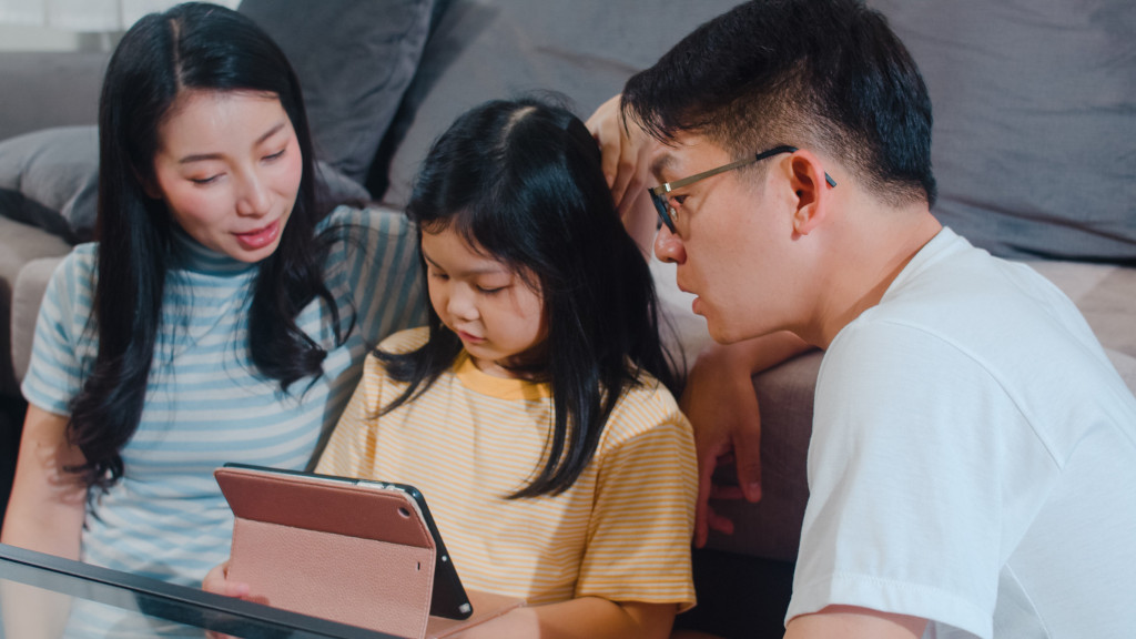 parents and daughter on tablet