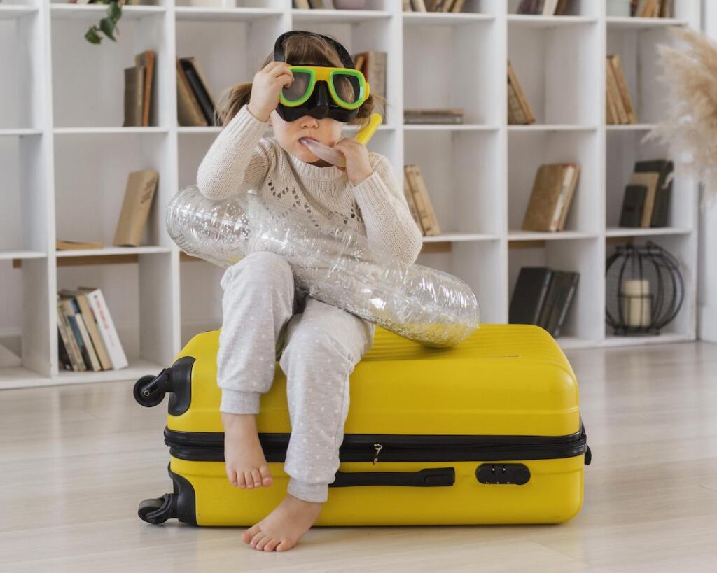 https://singaporemotherhood.com/wp-content/uploads/2023/10/girl-sitting-luggage-1024x819.jpg