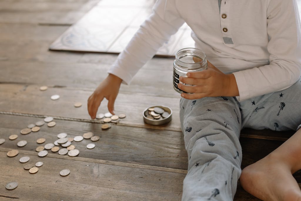 Child putting coins, money, into a jar