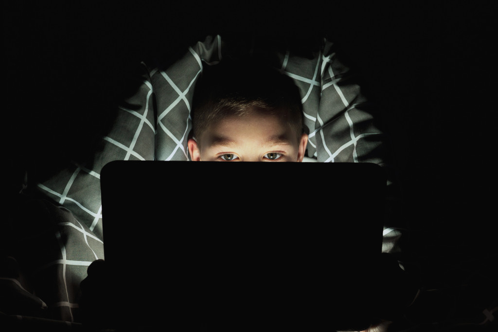 Boy with laptop in the dark