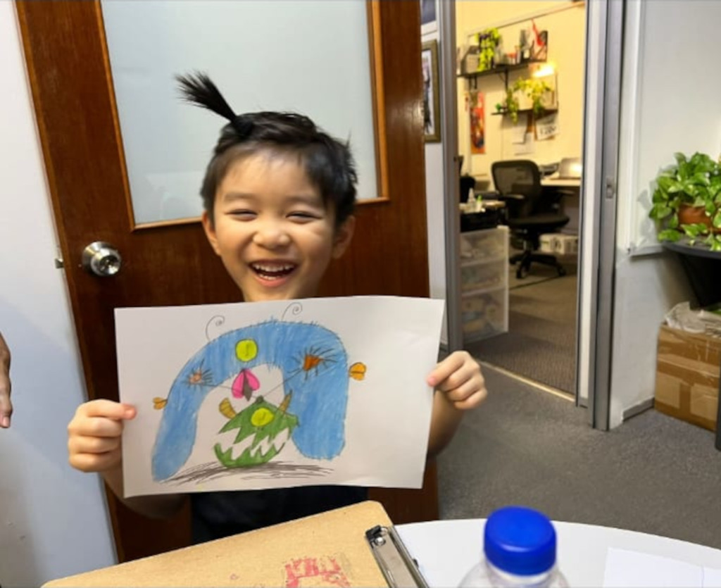 Happy Jacus holding a MonstroJ drawing